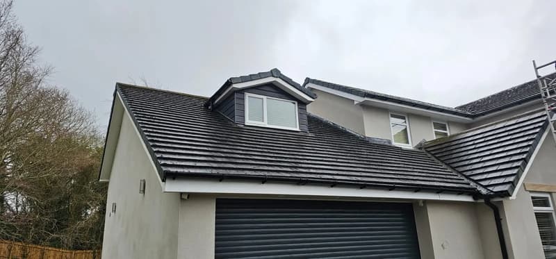 Dark tiled roof with dormer windows and white fascia boards